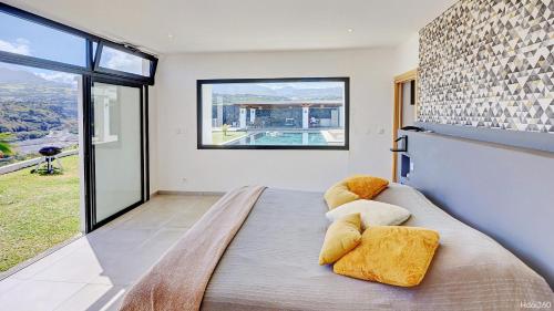 a bedroom with a bed and a large window at La Villa Phoenix in Saint-Pierre