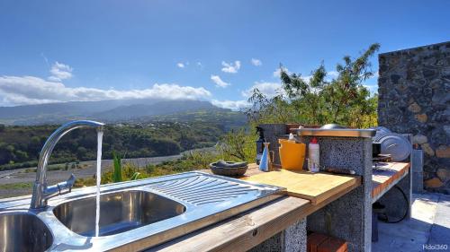 a kitchen sink with a view of a mountain at La Villa Phoenix in Saint-Pierre