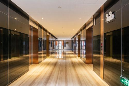 an empty hallway of an office building with glass walls at Guangzhou He She Art Apartment in Guangzhou