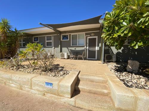 a house with a bench in front of it at Getaway Villas Unit 386 in Exmouth