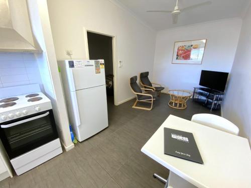 a kitchen with a stove and a refrigerator and a table at Getaway Villas Unit 386 in Exmouth