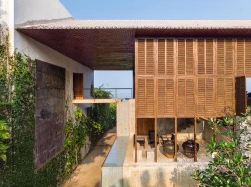 a house with wooden shutters and a patio at Villa Vista by The Serendipity Collection in Mirissa