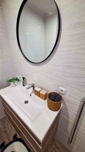 a bathroom with a sink and a mirror at Šiauliai Central Cozy Apartment in Šiauliai