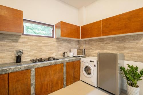 a kitchen with a washing machine and a microwave at Seven Residence in Seminyak