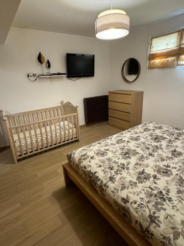 a bedroom with a bed and a tv on the wall at Home Garden in Igoumenitsa