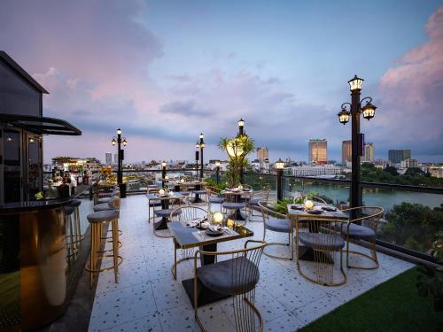 a restaurant with tables and chairs on a balcony at L'Signature Hotel & Spa in Hanoi