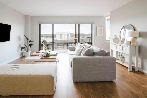 a white living room with a couch and a bed at Martha Cove Family Retreat in Safety Beach