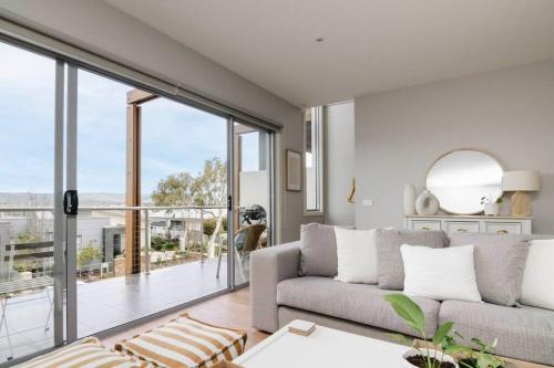 a living room with a couch and a large window at Martha Cove Family Retreat in Safety Beach