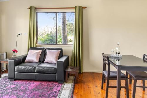a living room with a couch and a table and a window at Montville Country Cabins in Montville
