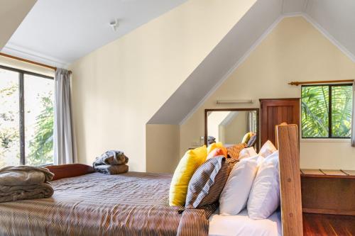 a bedroom with a bed with lots of pillows at Montville Country Cabins in Montville