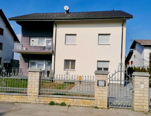 a white house with a fence in front of it at Apartman Tony Deluxe near Zagreb Airport in Velika Gorica