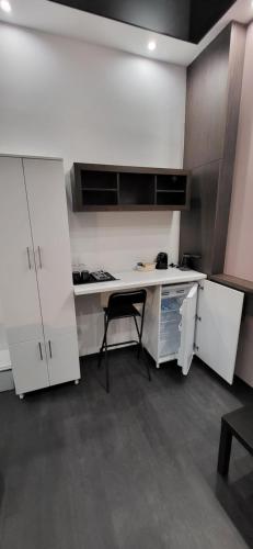 a kitchen with white cabinets and a black chair at Bumerang Apartmans, New Belgrade, Belgrade Arena in Belgrade