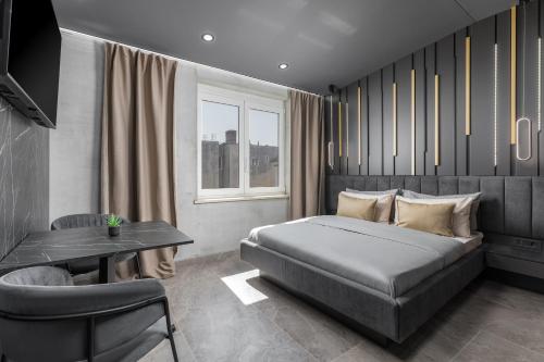 a bedroom with a bed and a table and a window at Center Apartments BAG, With PRIVATE FREE PARKING in Pula
