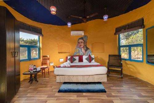 une chambre avec un lit avec un tableau sur le mur dans l'établissement Arise Ethnic Village Resort - Manesar Bilaspur, à Gurgaon