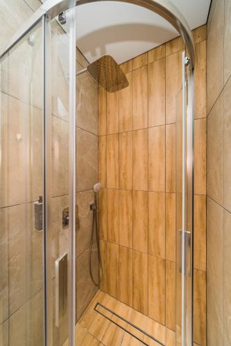 a shower with a glass door in a bathroom at Zaliakalnio Terasos apartamentai 2 in Kaunas