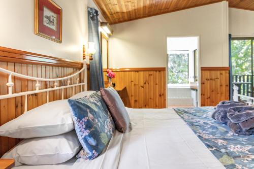 a bedroom with a large bed and a window at Montville Country Cabins in Montville