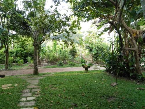 a garden with a tree and a stone path at Rooms 154 in Minuwangoda
