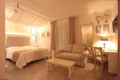 ein Schlafzimmer mit einem Bett, einer Couch und einem Tisch in der Unterkunft Relais in Contrada in Lucera
