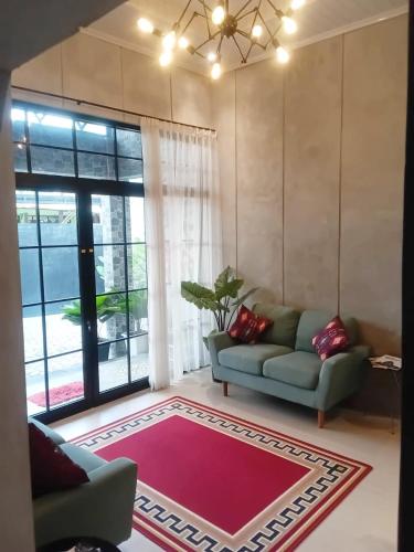 a living room with a couch and a large window at 24StaycationHome in Kejayan