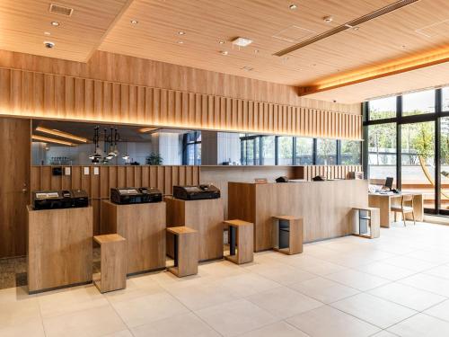 a lobby with wooden walls and wooden stools at Nishitetsu Hotel Croom Hakata Gion Kushida Shrine in Fukuoka