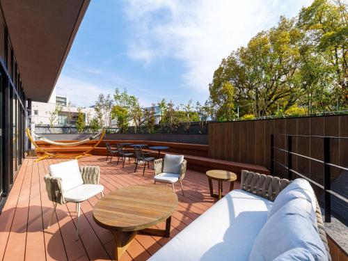 a patio with chairs and tables on a building at Nishitetsu Hotel Croom Hakata Gion Kushida Shrine in Fukuoka