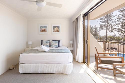 a bedroom with a bed and a balcony at Columbia Beachfront Apartments on Rainbow Bay in Gold Coast
