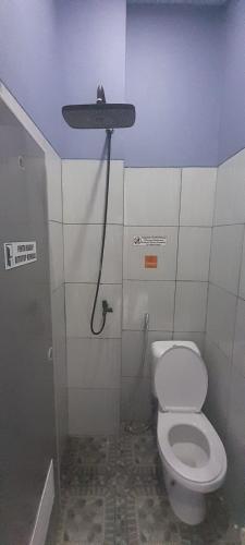 a bathroom with a toilet with a light on the ceiling at My Homestay SYARIAH in Sarongge
