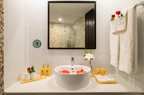 a bathroom with a large white sink and a mirror at Sandals Lily Hotel in Da Lat