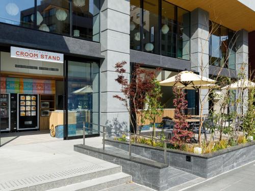 a building with an umbrella in front of a store at Nishitetsu Hotel Croom Hakata Gion Kushida Shrine in Fukuoka