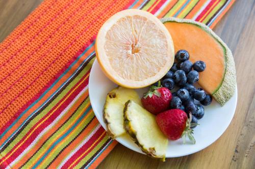 a white plate with fruit on a table at Santiago Resort - Palm Springs Premier Gay Men’s Resort in Palm Springs