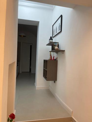 un corridoio con una parete bianca con uno scaffale di Spinelli house a Napoli
