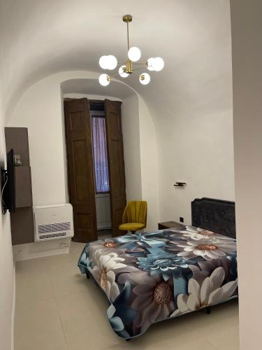 una camera da letto con un letto e un lampadario di Spinelli house a Napoli