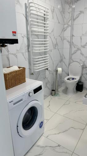 a washing machine in a bathroom with a toilet at Apartament Grójec in Grójec
