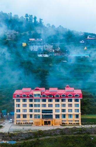 a building with a red roof in the fog at Fortune Park Kufri, Shimla - Member ITC Hotels' Group in Shimla