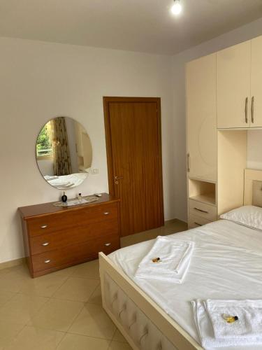 a bedroom with a white bed and a mirror at Emily House in Fier