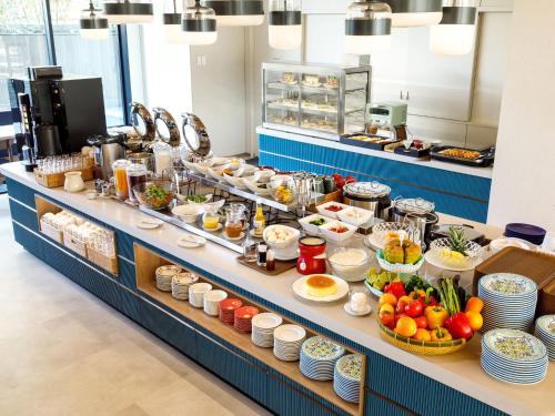 a buffet line with food on display in a restaurant at Nishitetsu Hotel Croom Hakata Gion Kushida Shrine in Fukuoka