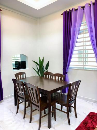 a dining room with purple curtains and a table and chairs at Tokwan Homestay, Alor Setar Kedah in Alor Setar