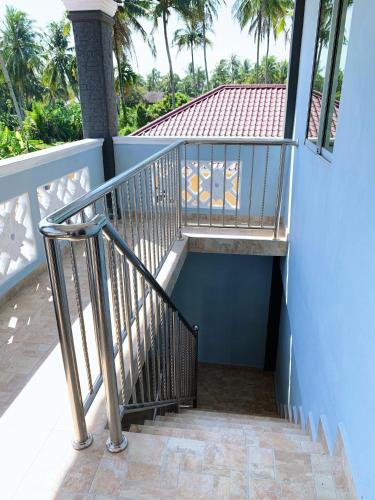 a staircase leading up to a blue building with palm trees at Tokwan Homestay, Alor Setar Kedah in Alor Setar
