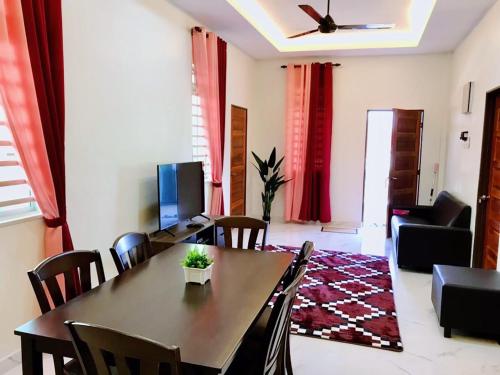 a living room with a table and chairs and a television at Tokwan Homestay, Alor Setar Kedah in Alor Setar