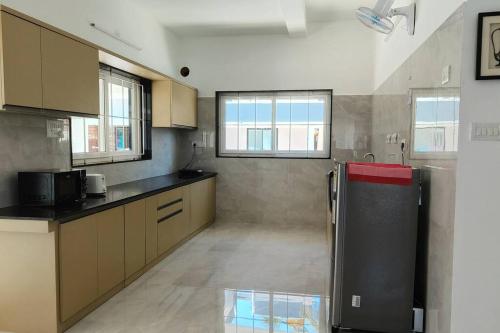 a kitchen with a black refrigerator in a room at Sunset Bay Beach Villa in Mangalore
