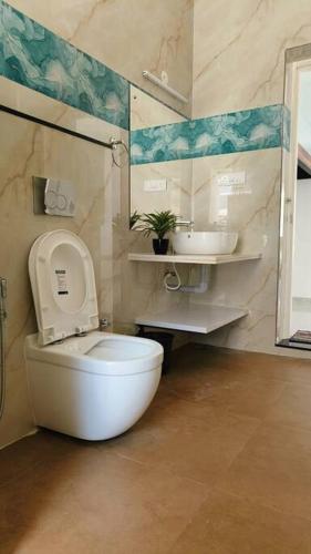 a bathroom with a toilet and a sink at Sunset Bay Beach Villa in Mangalore