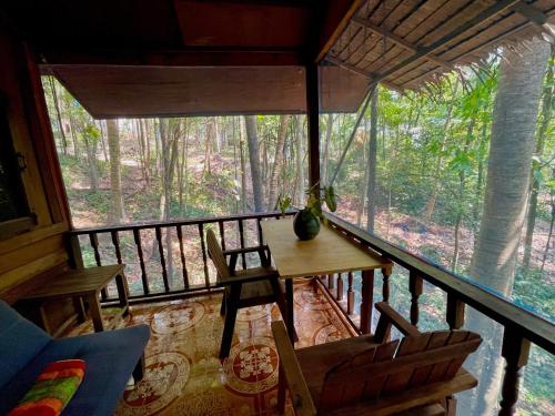 a room with a table and chairs on a balcony at Pyramid Yoga Koh Phangan in Koh Phangan