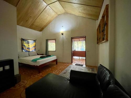 a living room with a bed and a couch at Pyramid Yoga Koh Phangan in Koh Phangan