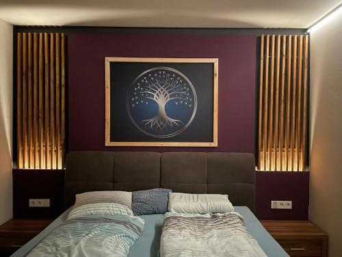 a bedroom with a bed with a tree picture on the wall at Modernes Haus mit super Aussicht in Windischgarsten