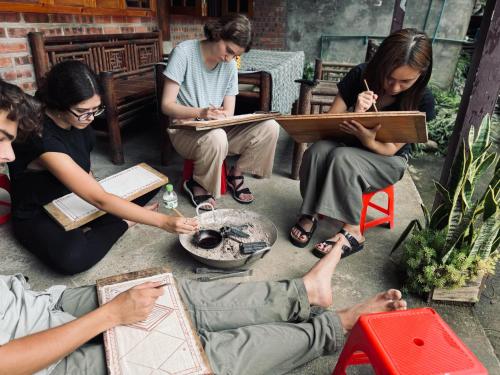 a group of people sitting on the ground reading at Surelee Homestay in Sa Pa