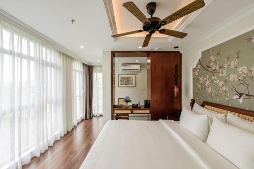 a bedroom with a bed and a ceiling fan at Lestar Hotel Hanoi in Hanoi