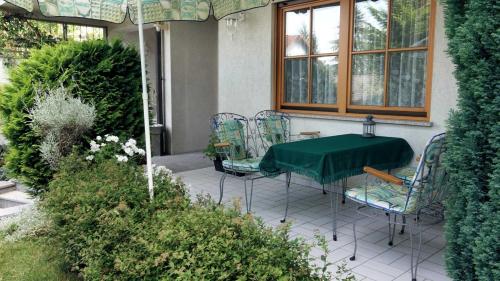 a table and chairs on a patio with a green table at Ferienwohnung Armitter in Neckargemünd