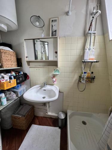 une salle de bain avec un lavabo et une baignoire dans l'établissement Charmant T2 parisien avec balcon, à Paris