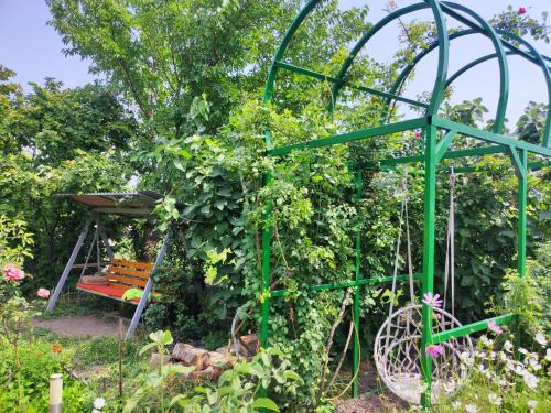a garden with a green arbour and a bench at Our Village in Ashtarak