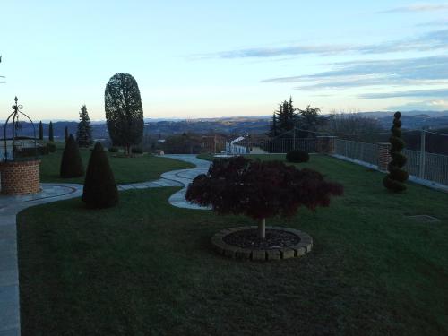 a garden with a tree in the grass at B&B Cascina Bellavista in Tigliole